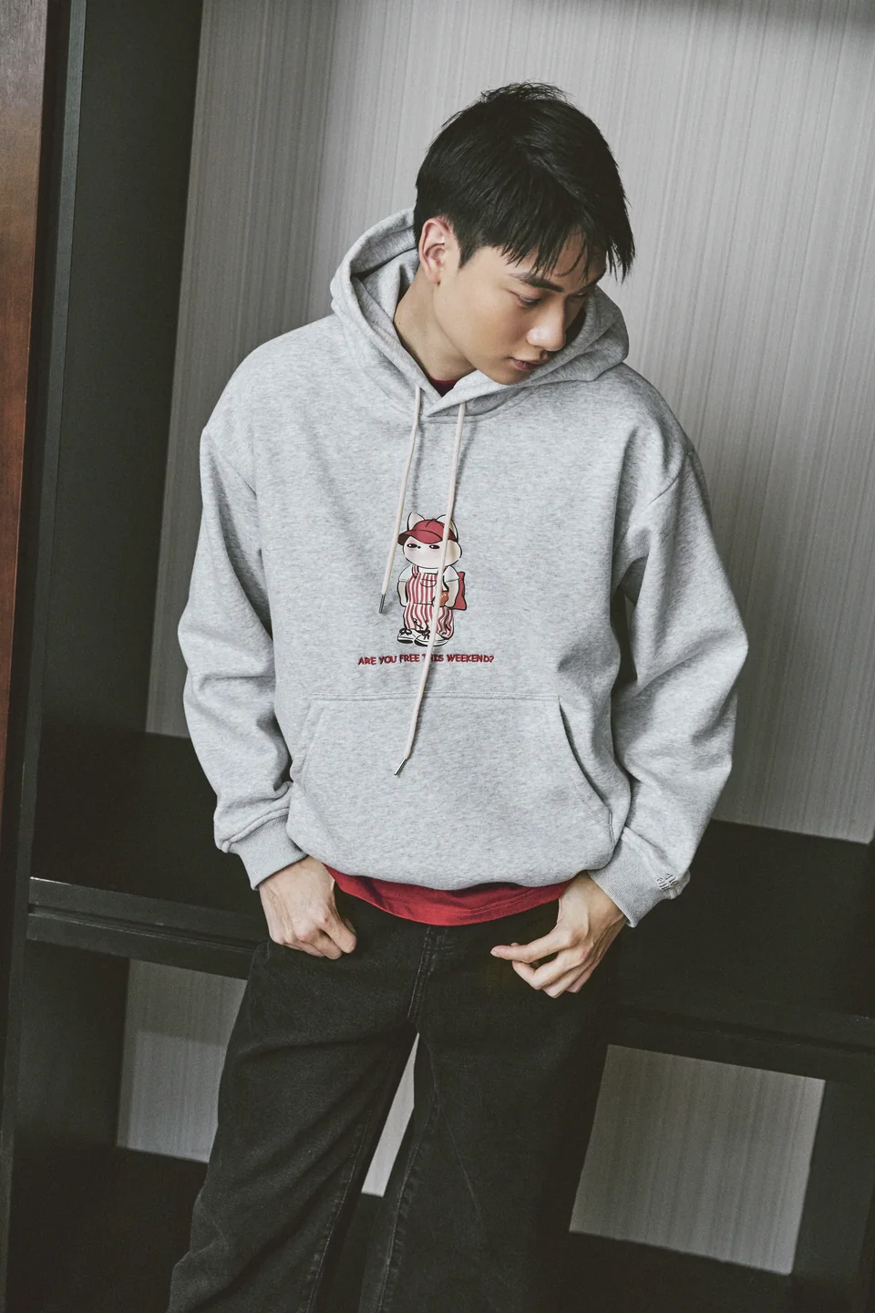 Hoodie Free Weekend xám phối cùng áo trong đỏ và quần đen.