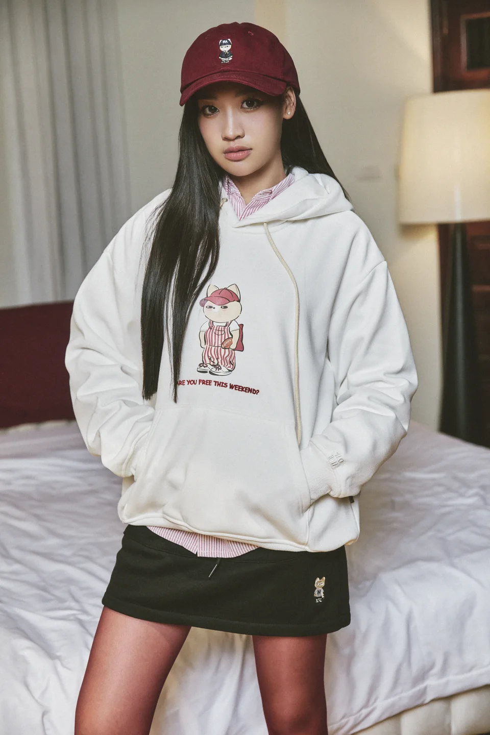 Hoodie Free Weekend trắng phối cùng sơ mi kẻ và mũ màu đỏ trầm.